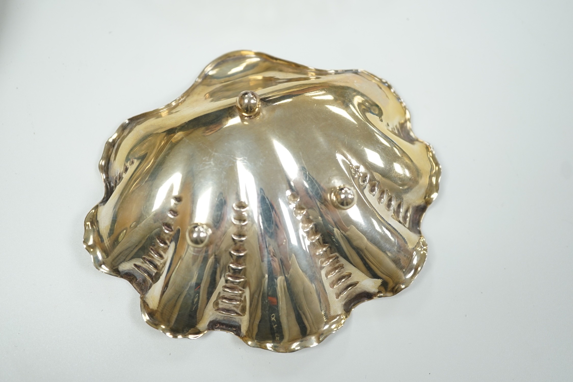 A modern silver mounted bottle coaster and two continental white metal small dishes.